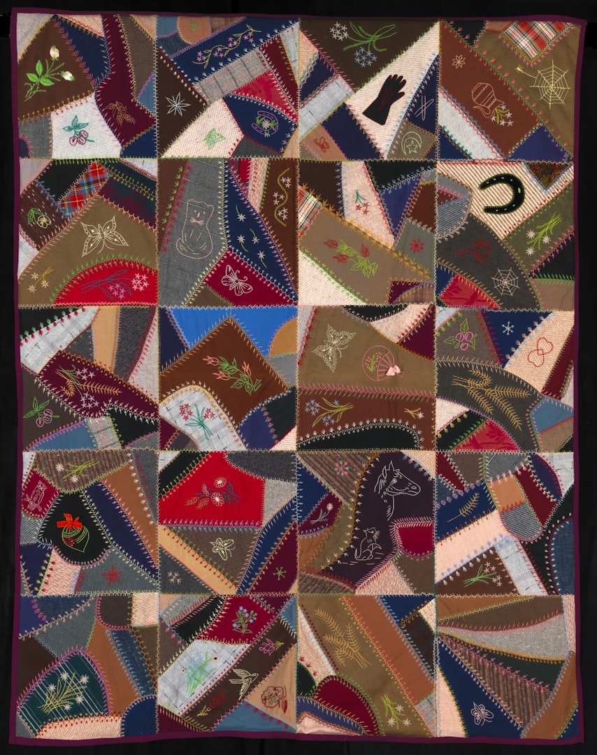 Intricate patchwork quilt featuring diverse embroidered patterns and shapes